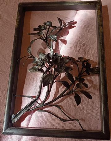 Antieke zwart houten wanddecoratie met bloemen van metaal.