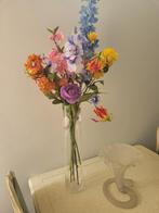 Hoge glazen vaas met kunstbloemen