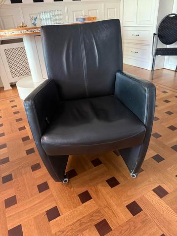 Drie zwarte leren stoelen met wieltjes