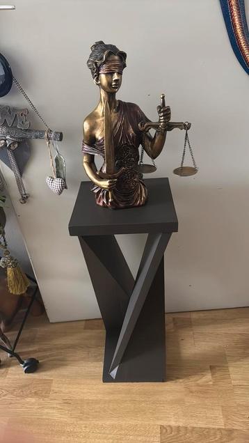 Vrouwe justitia op houten zuil beschikbaar voor biedingen