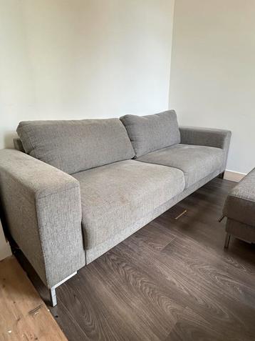 Grijze bank met hocker