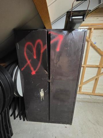 Beschadigde ijzeren kast met graffiti beschikbaar voor biedingen