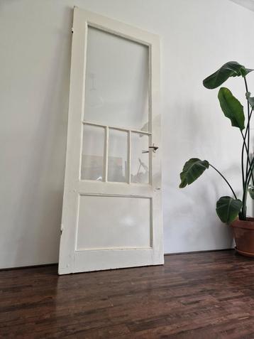 Oude tuindeur met glas beschikbaar voor biedingen