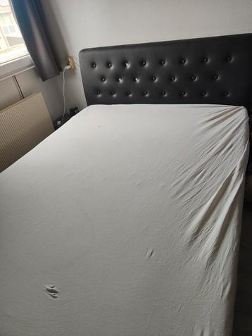 Tweepersoonsbed met zwart hoofdbord beschikbaar voor biedingen