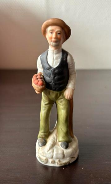 Antiek beeldje van een man met mand en stok beschikbaar voor biedingen