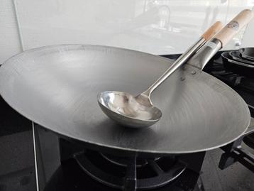Stalen wokpan met lepel beschikbaar voor biedingen