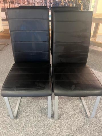 4 zwarte leren eetkamerstoelen beschikbaar voor biedingen