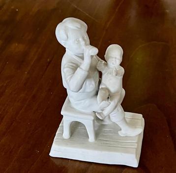 Porselein beeldje Drinkende man met baby beschikbaar voor biedingen