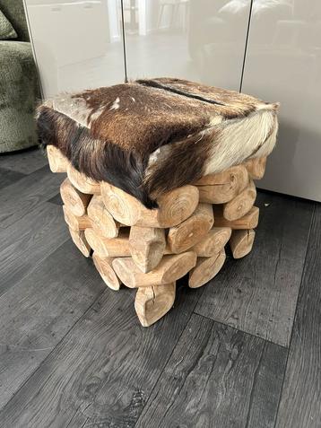 Poef met dierenvacht en hout beschikbaar voor biedingen
