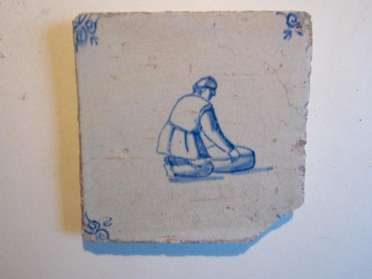 een 17e eeuwse tegel met een knielend mannetje, Antiek en Kunst, Antiek | Wandborden en Tegels, Ophalen of Verzenden
