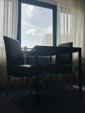 Eettafel met 2 zwarte stoelen beschikbaar voor biedingen