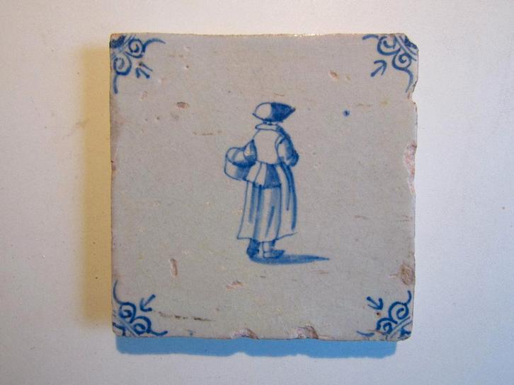 een 17e eeuwse tegel met een dame met boodschappen tas, Antiek en Kunst, Antiek | Wandborden en Tegels, Ophalen of Verzenden