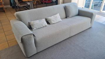 3 persoons zitbank met licht blauwe stoffen bekleding.