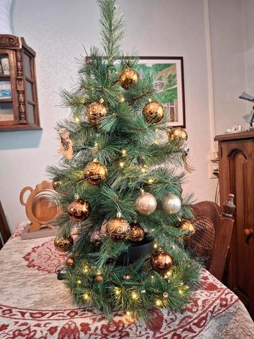 Prachtige kerstboom met lichtjes en ballen beschikbaar voor biedingen