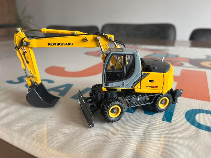 New Holland MH 5.5 mobiele graafmachine ROS, Hobby en Vrije tijd, Modelauto's | 1:50, Nieuw, Hijskraan, Tractor of Landbouw, Overige merken