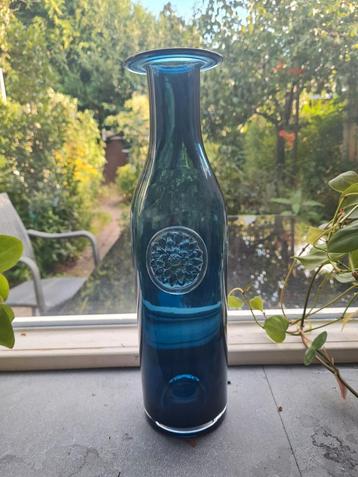 Blauwe glazen vaas met bloem beschikbaar voor biedingen
