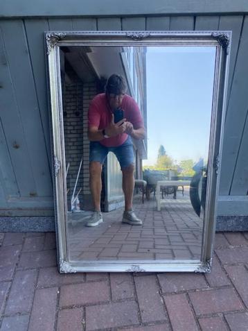 Grote spiegel met zilverkleurige lijst beschikbaar voor biedingen