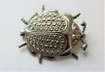 Grote broche dun metalen kever met roze oogjes beschikbaar voor biedingen