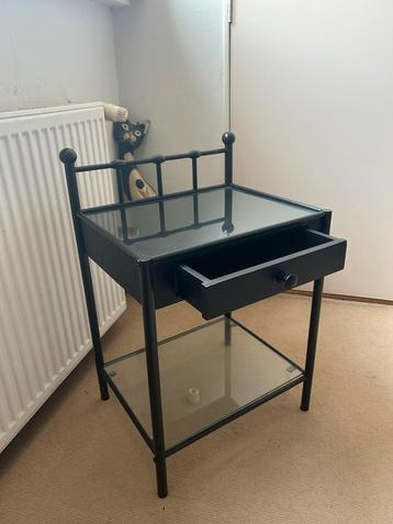 Zwart metalen nachtkastje met glazen blad beschikbaar voor biedingen