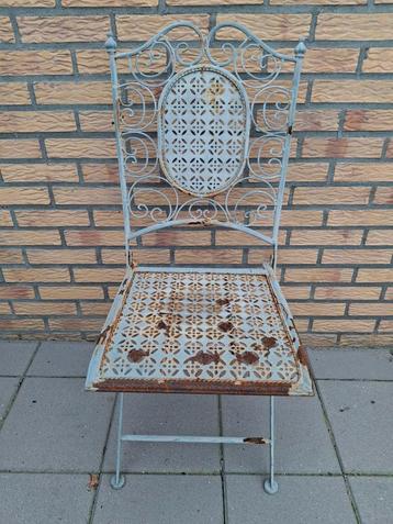 Oude metalen tuinstoel met sierlijk design beschikbaar voor biedingen