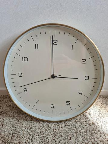 Wandklok met goudkleurigs rand beschikbaar voor biedingen
