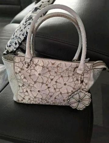 Mooi Guess zilverkleurige draagtas, is weinig gebruikt.

Vas beschikbaar voor biedingen