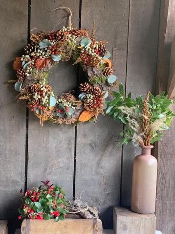 Herfstkrans met dennenappels en bessen en dadels beschikbaar voor biedingen