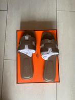 Nieuwe Hermes Oran Sandalen - Maat 37 & 40 - Etoupe, Kleding | Dames, Schoenen, Ophalen of Verzenden, Nieuw, Beige, Slippers