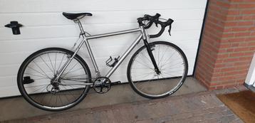 Sportieve zilverkleurige gravelbike beschikbaar voor biedingen