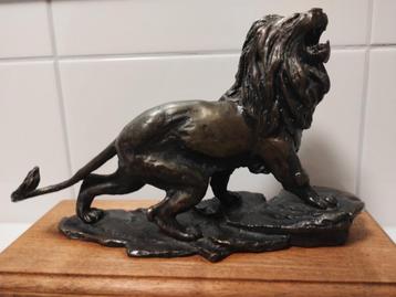 Antiek bronzen leeuw op houten voet beschikbaar voor biedingen