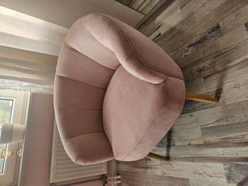 Roze fauteuil met houten pootjes.