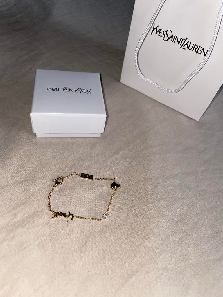 Goudkleurig Yves Saint Laurent armband, Overige materialen, Gebruikt, Ophalen of Verzenden, Met bedels of kralen