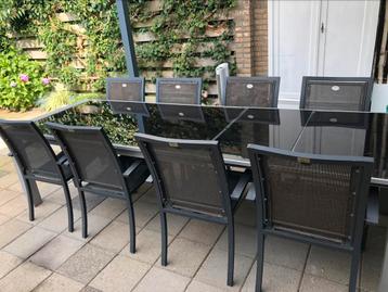 Glazen tuintafel met 8 stoelen beschikbaar voor biedingen