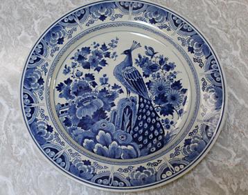 Kapitaal wandbord Porcelijne Fles Delft met pauw 1947 beschikbaar voor biedingen
