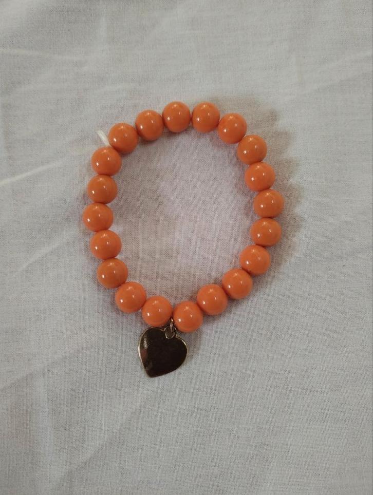 Elastische armband met oranje kralen en bedel hartje, Sieraden, Tassen en Uiterlijk, Armbanden, Zo goed als nieuw, Oranje, Ophalen of Verzenden