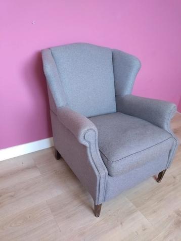 Grijze fauteuil met donkere houten poten beschikbaar voor biedingen