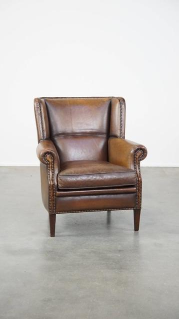 Subtiele, comfortabele donkere schapenleren fauteuil beschikbaar voor biedingen