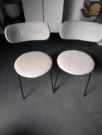 Twee grijze eetstoelen. 