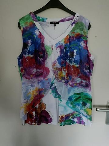 Een witte Tuniek met V-Hals en bloemen op de voorzijde. beschikbaar voor biedingen