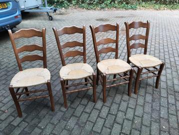 Vier houten stoelen met rieten zitting beschikbaar voor biedingen