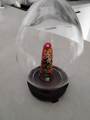 Ei van glas op houten voet, met matroesjka  beschikbaar voor biedingen