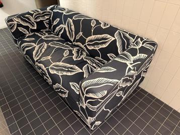 Comfortable 2 zits bank met zwart wit bladmotief beschikbaar voor biedingen