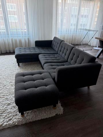 Grijze hoekbank met chaise longue en voetenbank beschikbaar voor biedingen