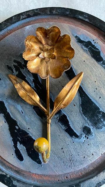 Goudkleurige metalen ophanghaak met bloem beschikbaar voor biedingen