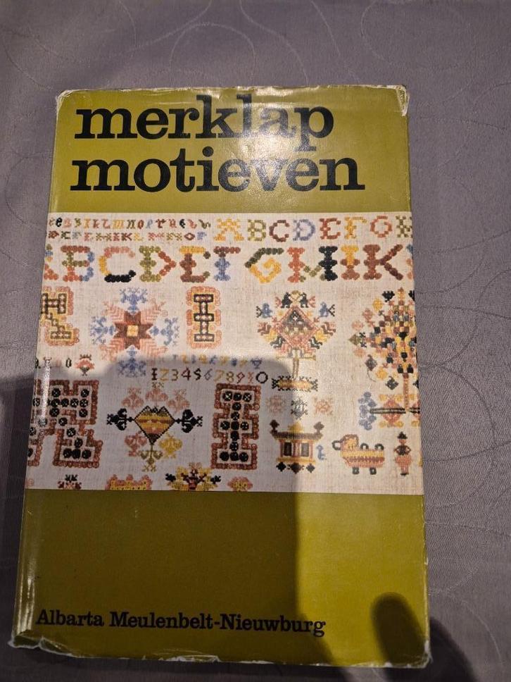 Boek Merklapmotieven en hun symboliek, Hobby en Vrije tijd, Borduren en Borduurmachines, Zo goed als nieuw, Patroon, Handborduren