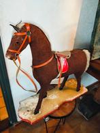 Antiek brocante grote oude houten paard op plank en wielen