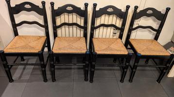 Vier zwarte houten stoelen met rieten zitting beschikbaar voor biedingen