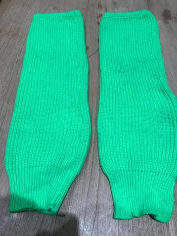 Paar fel groene beenwarmers beschikbaar voor biedingen