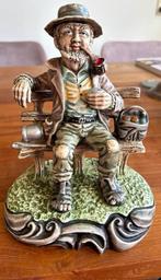 Vintage beeldje Capodimonte stijl; man met pijp op bank, Antiek en Kunst, Ophalen
