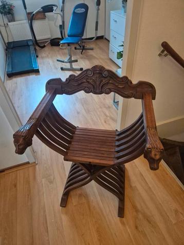Antieke houten stoel met leeuwenkoppen beschikbaar voor biedingen